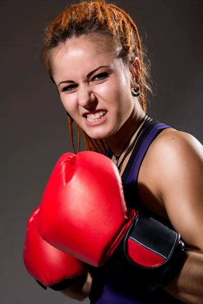 Piękna dziewczyna z czerwone Rękawice bokserskie, agresywne i patrząc na — Zdjęcie stockowe