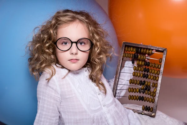 Girl schoolgirl with wooden abacus. — Stock Photo, Image