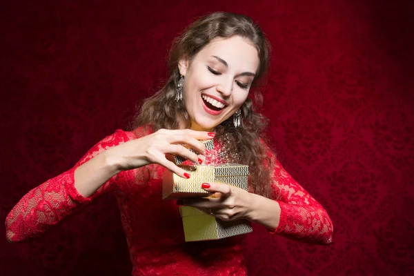 Glückliches Mädchen im roten Kleid mit Geschenkbox. — Stockfoto