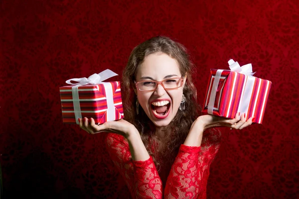 Menina gritando feliz em vestido vermelho com duas caixas de presente — Fotografia de Stock