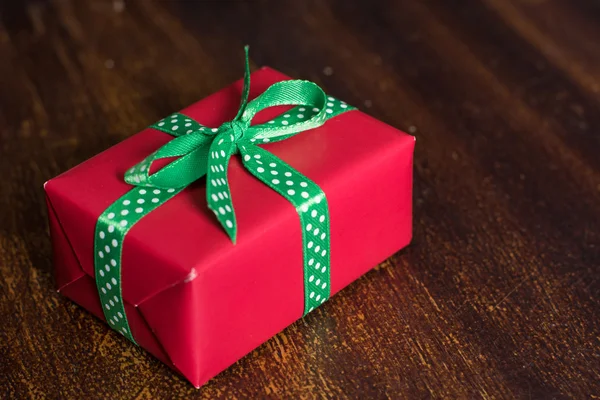 Boîte cadeau rouge repose sur un fond en bois — Photo