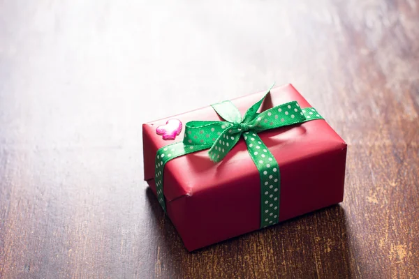 Caja de regalo roja con un corazón se encuentra sobre un fondo de madera —  Fotos de Stock