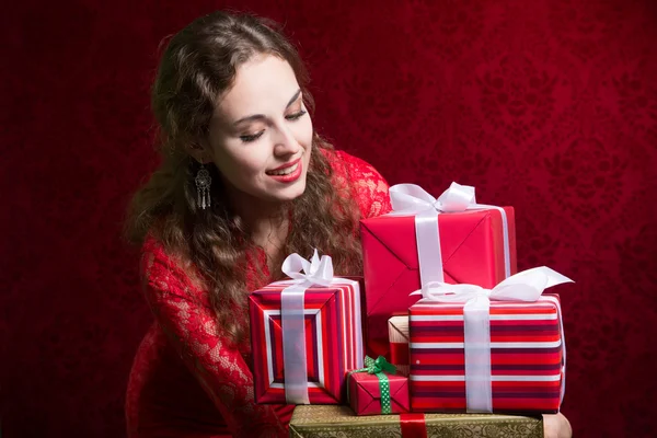 Beautiful girl looking at gifts. — Stock Photo, Image