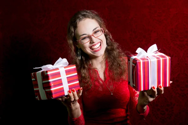 Gelukkig meisje in glazen met twee geschenken. — Stockfoto