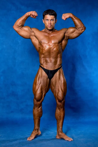 Bodybuilder flexing his muscles in studio Stock Picture