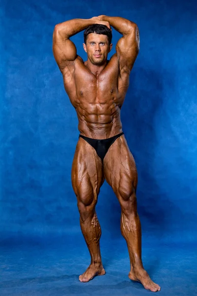 Athletic sports bodybuilder demonstrates posture — Stock Photo, Image