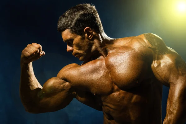 Handsome muscular bodybuilder demonstrates his muscles — Stock Photo, Image