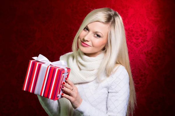 Porträtt av casual unga glada leende blondin hålla randig gåva — Stockfoto