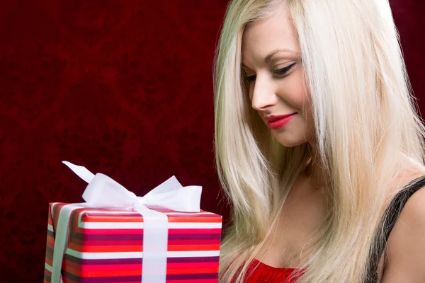 Portrait of casual young happy blonde hold striped gift box — Stock Photo, Image