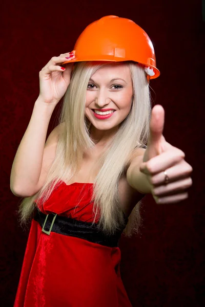 Portrait d'une jeune fille en costume de Père Noël et casque de la construction — Photo