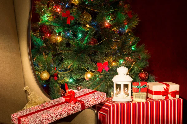 Interior de Navidad con árbol de Navidad iluminado y silla. Gi. — Foto de Stock