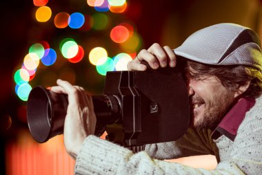 bir adam eski bir film kamerada şapkası