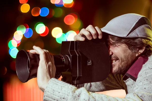 Een man draagt een pet met een oude filmcamera — Stockfoto