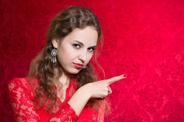 Portrait of a beautiful happy young woman pointing finger at a r — Stock Photo, Image