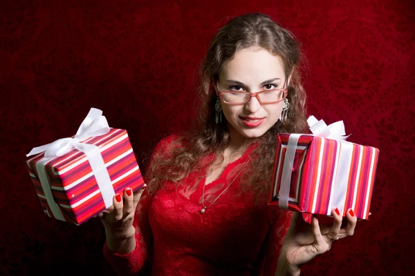 Portret van een jonge vrouw met twee gestreepte geschenken. — Stockfoto