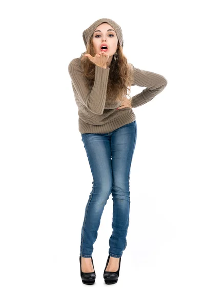 Encantadora jovem mulher de cabelos castanhos em uma camisola de comprimento completo sopra — Fotografia de Stock