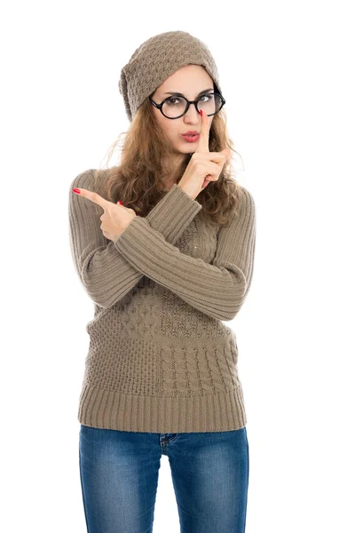 Girl in a beige sweater showing thumb to the side. Warning, adve — Stock Photo, Image