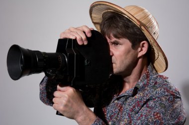 Gri bir backgrou üzerinde eski bir film kamera ile Hasır Şapkalı bir adam