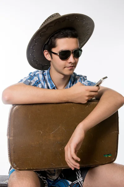 Portret młodzieńca w okulary z walizką. — Zdjęcie stockowe