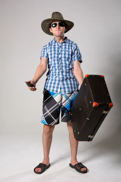 Nuoren miehen muotokuva aurinkolaseissa matkalaukku kädessä . — kuvapankkivalokuva