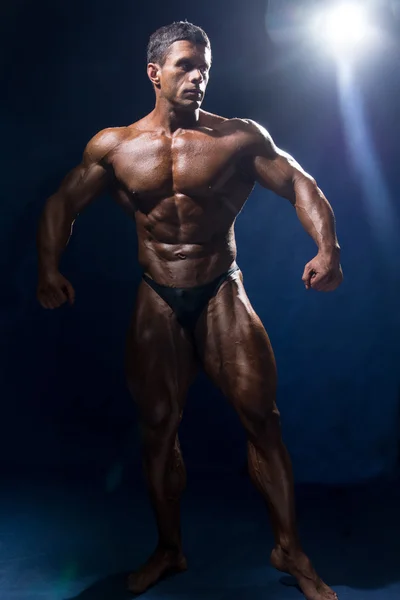 Ισχυρή και μυώδης άνδρας bodybuilder σε πλήρη ανάπτυξη. — Φωτογραφία Αρχείου