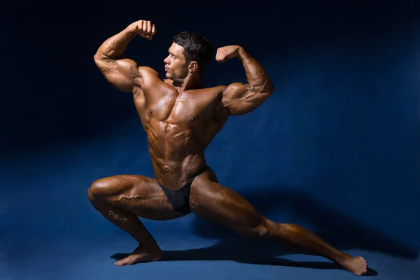 强壮的肌肉男健美展示他的肌肉. — 图库照片