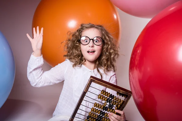 Doordachte krullend tiener meisje in glazen met houten abacus op de — Stockfoto