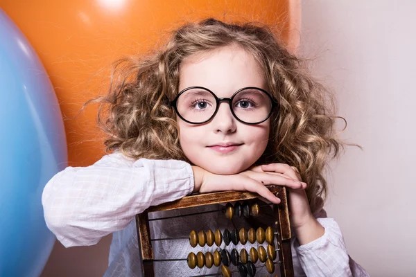 Funny, clever curly teen girl in glasses with wooden abacus on t — Stock Photo, Image