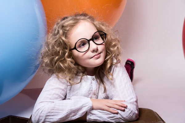 Portrait of curly teen girl in glasses on the background of larg — Stock Photo, Image