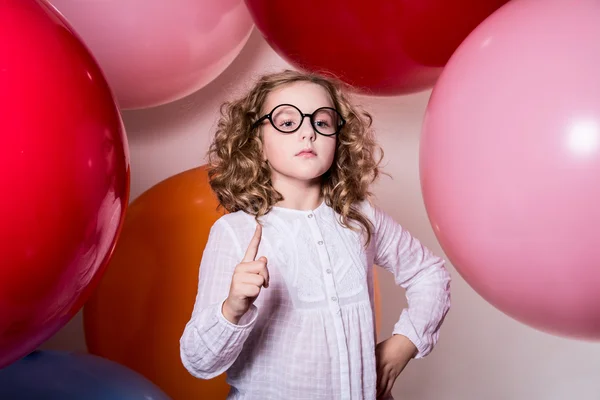 Vrij ernstige meisje in een witte jurk met een verhoogde wijsvinger — Stockfoto