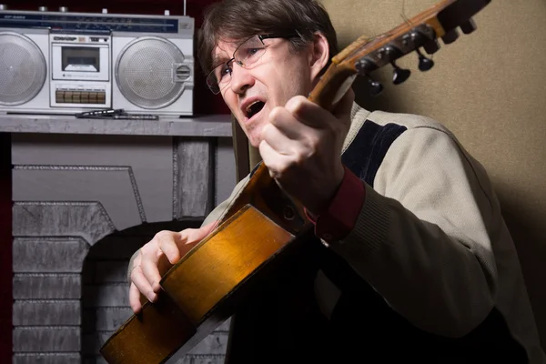 Hombre adulto tocando la guitarra y realiza npesnyu . — Foto de Stock