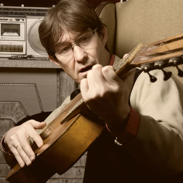 Bard man in glasses playing guitar. Guitarist sings a song about — Stock Photo, Image