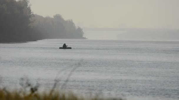 Un pescador en un bote de goma flotando en el río . — Vídeos de Stock