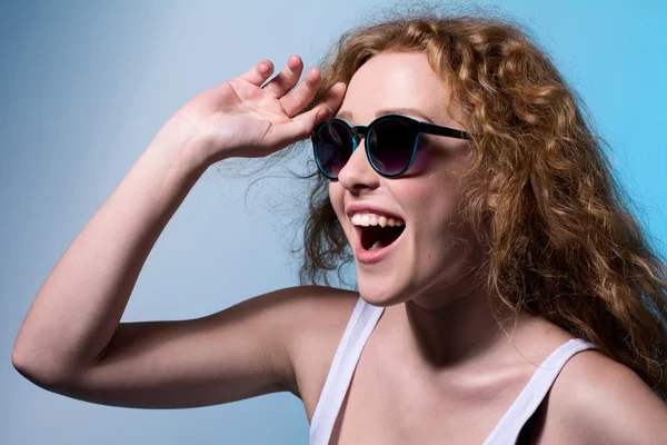 Pretty young emotional girl in sunglasses looking to the side — Stock Photo, Image