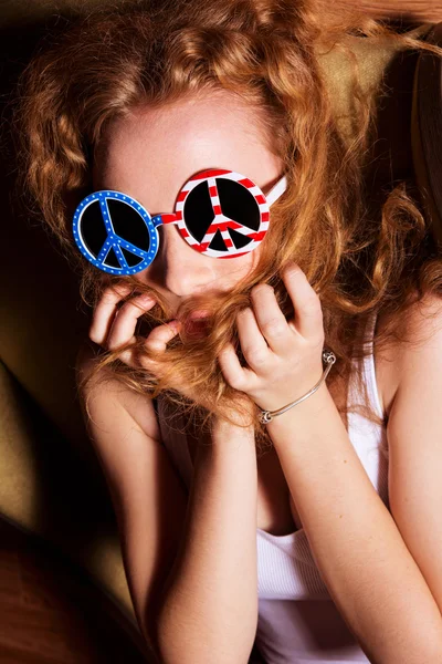 Jeune fille aux cheveux bouclés portant des lunettes de soleil avec l'Américain — Photo