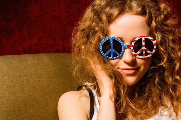 Young girl with curly hair wearing sunglasses with the American — Stock Photo, Image