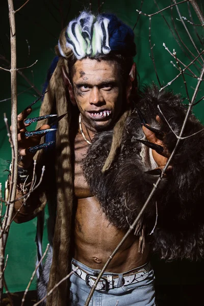 Hombre lobo con uñas largas y dientes torcidos entre las ramas de —  Fotos de Stock