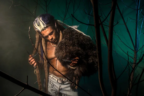 Werewolf with a skin on his skin and long nails among tree branc — Stock Photo, Image