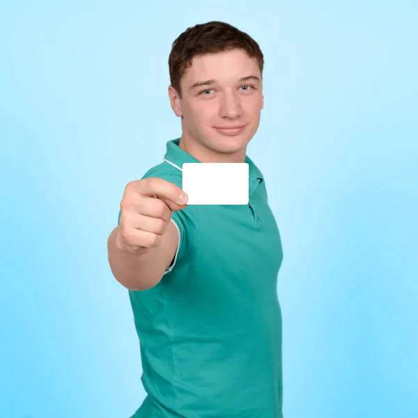 Um homem de sucesso em uma camisa verde mostrando cartão em branco — Fotografia de Stock