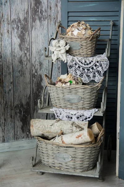 Background rustic veranda with a shelf with baskets and angels — Stock Photo, Image