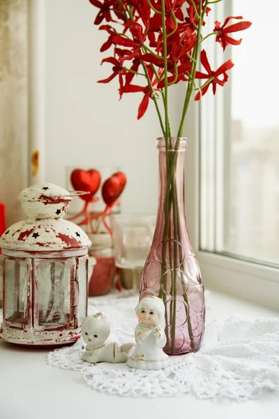 Close-up de estatuetas de porcelana com flores no parapeito da janela um — Fotografia de Stock