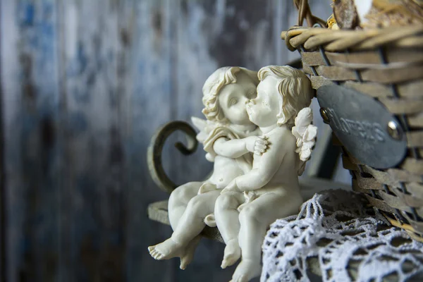 Figurinas anjos sentados em um banco perto da cesta de vime — Fotografia de Stock