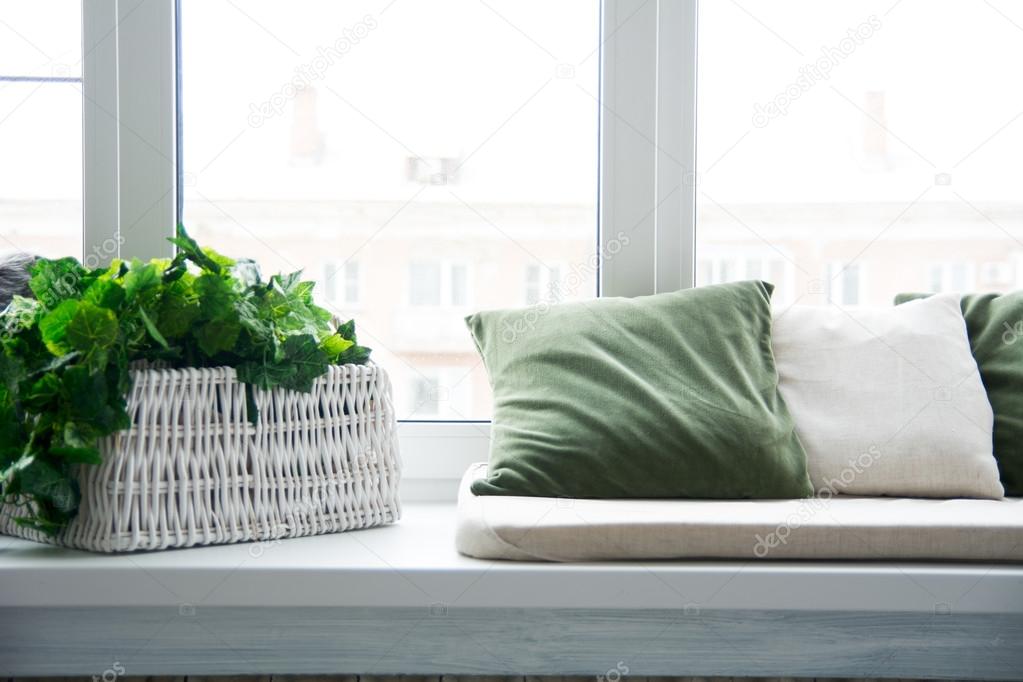 Pillows on the windowsill and plastic window