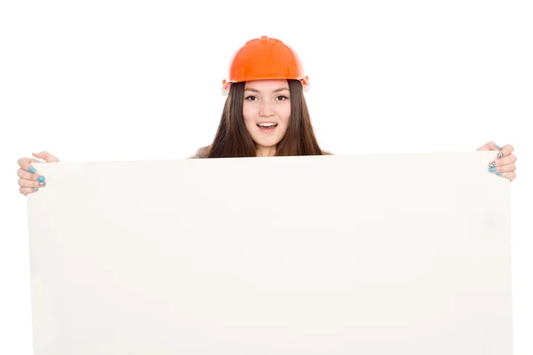 Flicka builder i hjälmen visar en tom banner. — Stockfoto