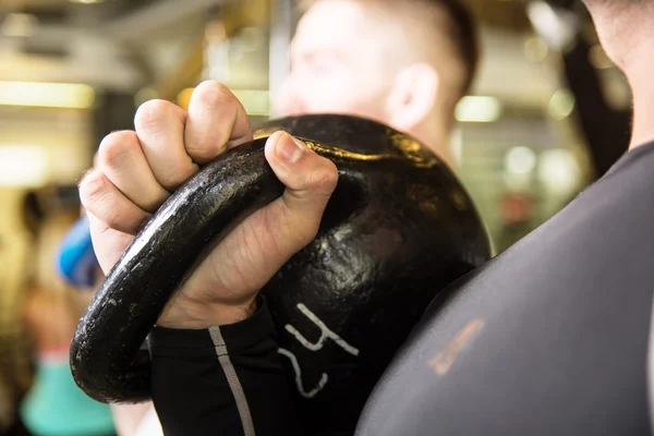 Closeup swing kettlebell training two young men in the gym — Stock Photo, Image