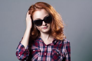 Bir gülümseyen güzel genç Kızıl saçlı kız sunglas portresi