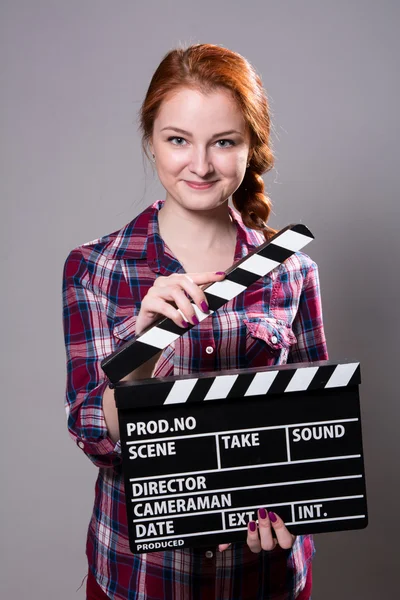Piękny uśmiechający się rudowłosa kobieta trzymając kino klakier — Zdjęcie stockowe