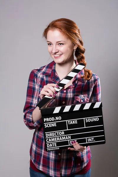 Bela sorridente mulher ruiva segurando um filme palmas — Fotografia de Stock