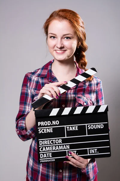 Bela sorridente mulher ruiva segurando um filme palmas — Fotografia de Stock