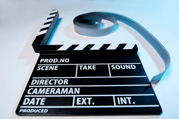 Close-up de um filme palmas e filme de vídeo em um backg luz — Fotografia de Stock